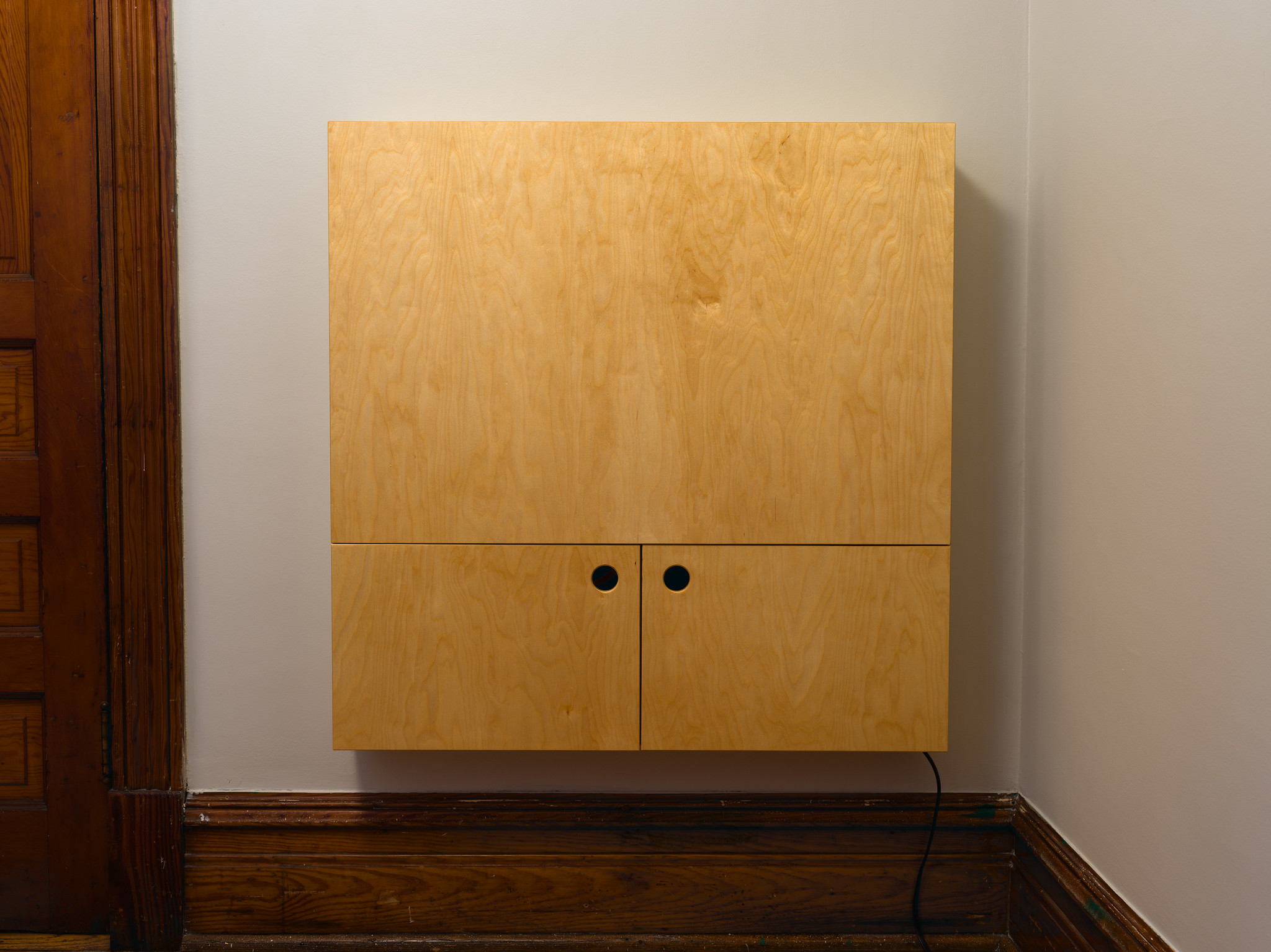A convertible, fold-down desk. It is currently closed, one large panel on the top and two doors on the bottom. Made from baltic birch.
