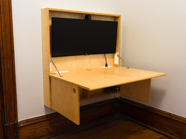 A convertible, fold-down desk. It is currently open with the desk folded down. The doors below can act as a supplemental support for the top. Made from baltic birch.
